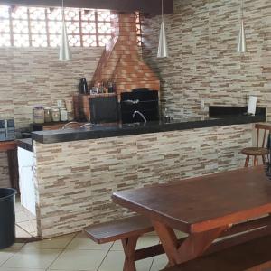 大坎普Sobrado lindo的厨房配有木桌和砖墙