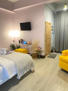 董里Triple J hotel Trang的卧室配有一张床,墙上配有电视。