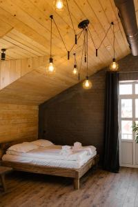 卡缅涅茨-波多利斯基Hotel Dynasty的一间设有床铺的卧室,位于带灯的木制房间内