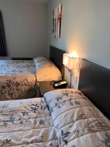 温尼伯克尔克弗尔德摩托酒店的客房设有两张床、一盏灯和一台笔记本电脑