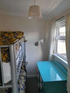 梅布尔索普B8 lovely chalet的小房间设有双层床和蓝色的书桌