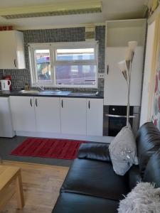 梅布尔索普B8 lovely chalet的带沙发的客厅和厨房