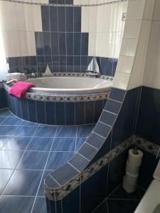 MoutierLa maison du petit bonheur的蓝色和白色的浴室设有浴缸