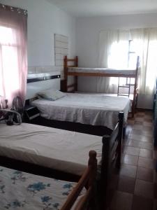 蓬塔格罗萨Pousada Bom Jesus的一间客房配有两张床和两张双层床。