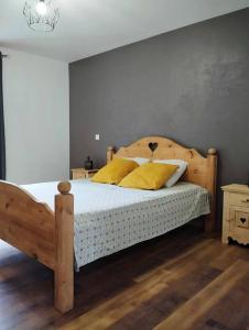 LathuilleLE MAZOT-SPA HIVER ET ETE-Piscine-Proche lac-Charme-Détente的一间卧室配有一张带黄色枕头的木床