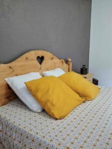LathuilleLE MAZOT-SPA HIVER ET ETE-Piscine-Proche lac-Charme-Détente的一张黄色和白色枕头的床