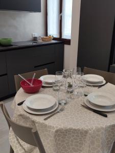 科内利亚诺AL PONTE design apartment的一张桌子上放有盘子和酒杯