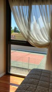 里奥夸尔托Apart Torre Parque del Río的从卧室的窗户可欣赏到网球场的景色