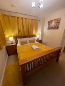 卡迪夫Holiday Home In Cardiff. Sleeps 6的一间卧室配有一张带两盏灯的大型黄色床。