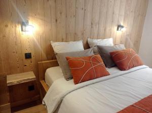 马格朗*Spacieux T3 Campagne proche lac*的一间卧室配有带两个橙色枕头的床