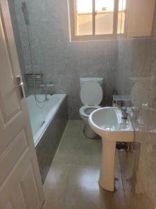 卢萨卡Beautiful 3 bedroom Apartment with own private bathroom的浴室配有盥洗盆、卫生间和浴缸。