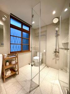 台南Humanlive的一间带玻璃淋浴和卫生间的浴室