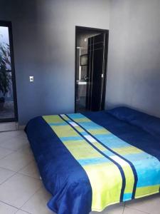 Casa Hogareña las estacas的一间卧室配有一张蓝色和黄色毯子的床