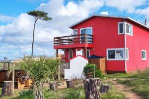 埃斯特角城Klimatisiertes Haus am Meer in Chihuahua的红色房子,有红色屋顶