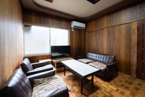 MitoyoSetouchi base - Vacation STAY 47136v的客厅配有皮革家具和桌子