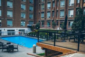 卡尔加里布莱克福特酒店的一座带桌椅的游泳池和一座建筑