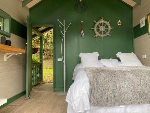 里奥内格罗Rancheria Loft Chalet, lago privado的绿色客房 - 带白色枕头的床