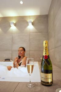 麦德林DUO BOUTIQUE HOTEL的浴缸内的一瓶香槟和一杯葡萄酒