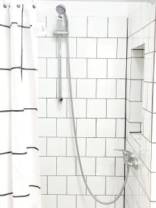 拉斯加莱塔斯Casa Veronica 3 , 1 dormitorio的白色瓷砖浴室内带软管的淋浴