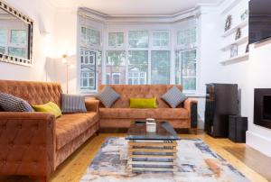 诺丁汉Mapperley Park Guesthouse的客厅配有棕色沙发和电视