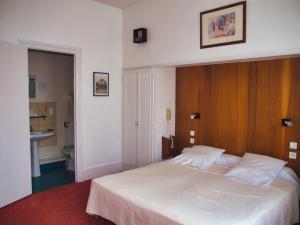沙泰勒吉永巴黎酒店的卧室配有一张白色大床和木制床头板