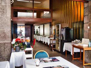 沙泰勒吉永巴黎酒店的一间带白色桌椅的餐厅和一间厨房