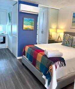 圣胡安KASA Galicia by the Sea - Cabana Studio Apt for 2 BEACHFRONT CONDO POOL的一间卧室配有一张带彩色毯子的床