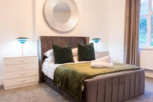 诺丁汉Mapperley Park Guesthouse的卧室配有一张大床,墙上装有镜子