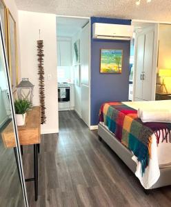 圣胡安KASA Galicia by the Sea - Cabana Studio Apt for 2 BEACHFRONT CONDO POOL的一间卧室配有一张带彩色毯子的床