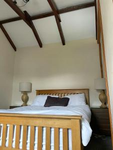 阿伯代尔Rose Cottage Trecynon Traditional 2 bed cottage Zip World Beacons Bike的一间卧室配有一张带两盏灯的木床。