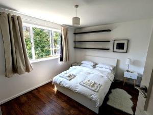 伦敦曼妙花园公寓的白色的卧室设有床和窗户