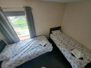 阿伯代尔Rose Cottage Trecynon Traditional 2 bed cottage Zip World Beacons Bike的带窗户的客房内的两张床