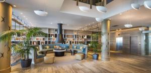 奥克兰奥克兰希尔顿酒店的大堂设有蓝色椅子和盆栽植物