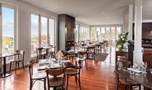 陶波希尔顿陶波湖酒店的餐厅设有桌椅和窗户。