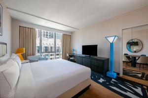 芝加哥theWit Chicago, a Hilton Hotel的酒店客房配有一张床、一张书桌和一台电视。