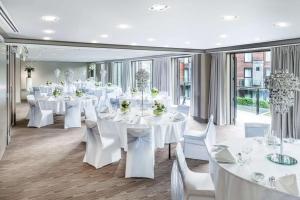 皇后镇皇后镇希尔顿逸林酒店的宴会厅配有白色的桌子和白色的椅子