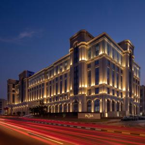 多哈The Plaza Doha, LXR Hotels & Resorts的一座白色的大建筑,晚上有灯