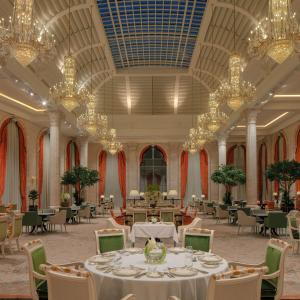 多哈The Plaza Doha, LXR Hotels & Resorts的宴会厅配有桌子和吊灯
