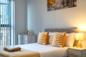 伯明翰Birmingham City Center - Luxury Stay 86的一间卧室配有带橙色和白色枕头的床