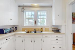 蒙彼利埃The Farmhouse B&B的白色的厨房配有水槽和微波炉