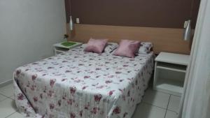 皮拉伊河畔巴拉Aconchegante Flat no Aldeia das Águas的一间卧室配有带粉红色枕头的床。