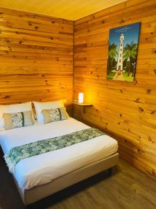 莫雷阿Bungalow KURA的卧室配有一张床铺,位于带木墙的房间内