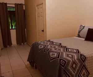 科马亚瓜Casa Colonial en casco Histórico的一间卧室配有一张带黑白毯子的床