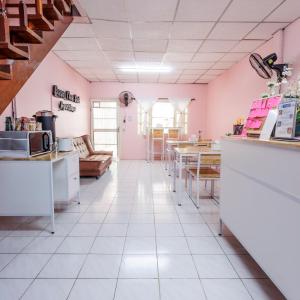 大城Baan Mee Suk Ayutthaya的厨房拥有粉红色的墙壁和白色的瓷砖地板。