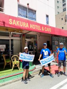 东京神保町樱花酒店的三名男子在旅馆前举着标牌