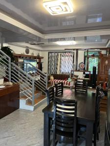 Laguindingan Town House的一间带桌椅和楼梯的用餐室