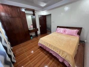 Laguindingan Town House的一间卧室配有一张带粉红色枕头的床