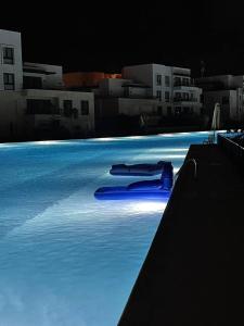 阿莱曼Ground chlat first row lagoon 2 bedrooms at Blanca marassi的夜间在水中漂流的游泳池