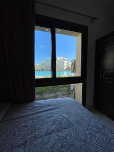 阿莱曼Ground chlat first row lagoon 2 bedrooms at Blanca marassi的一间卧室设有一张床和一个美景窗户。