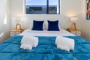 基督城Avon Haven City Escape - 1 bed 1 bath的一间卧室配有一张大床,提供蓝色的床单和枕头